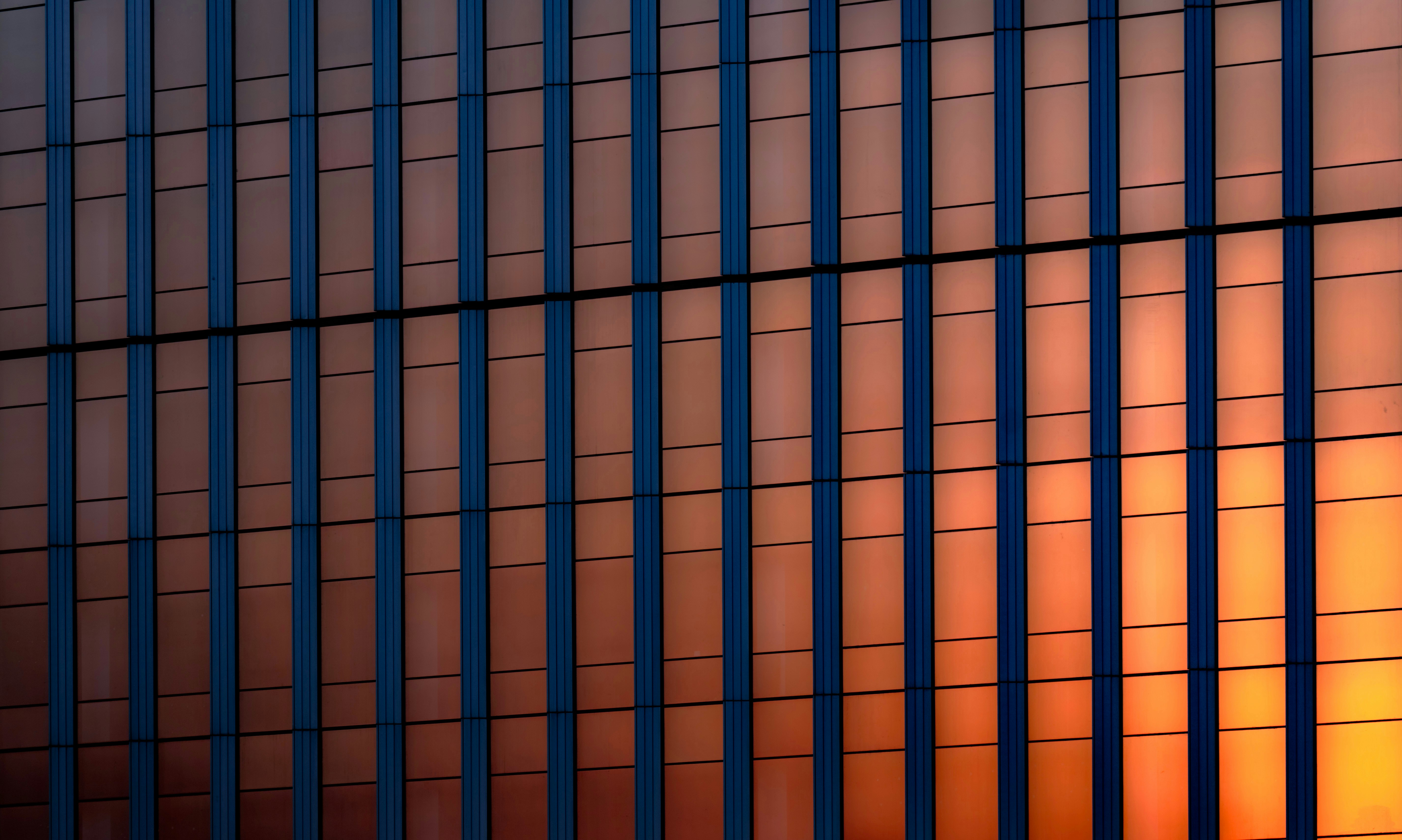 blue and orange vertical lines of a building reflect the sun